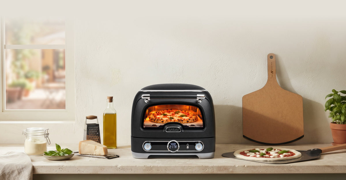 Val Cucina Pizza Oven on a kitchen counter with a fresh pizza
